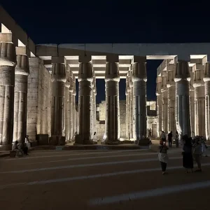 Luxor Temple colonnade illuminated at night with tourists, Egypt