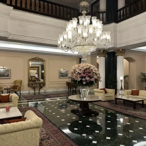 Luxury hotel lobby in Kolkata with crystal chandelier, marble floors, and tropical flower arrangement