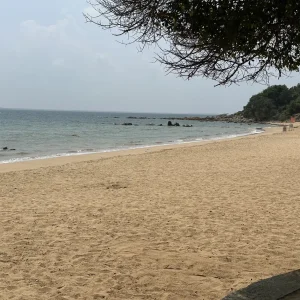 Golden sand beach with calm turquoise waters and rocky outcrops at Marble Beach, Trincomalee