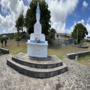 Reine de Rodrigues Virgin Mary statue monument with visitors on stone platform, Rodrigues Island