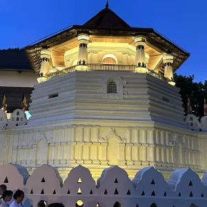 Temple of the Sacred Tooth Relic illuminated at night with traditional architecture in Kandy