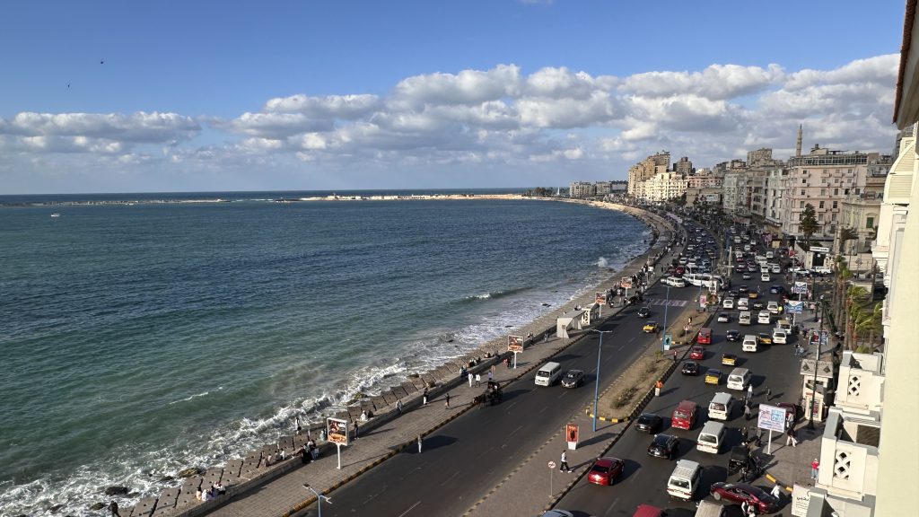 Alexandria’s Corniche with traffic and people walking along the Mediterranean coast, a popular add-on to a 10-Day Egypt Itinerary.