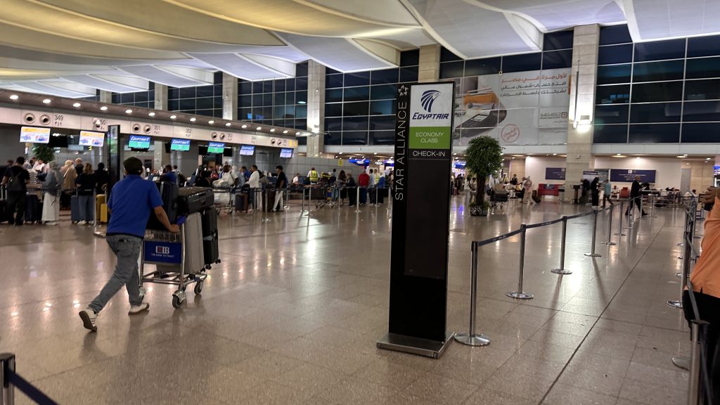 Travellers queuing at EgyptAir economy check-in inside Cairo International Airport on Day 10 of a 10-Day Egypt Itinerary.