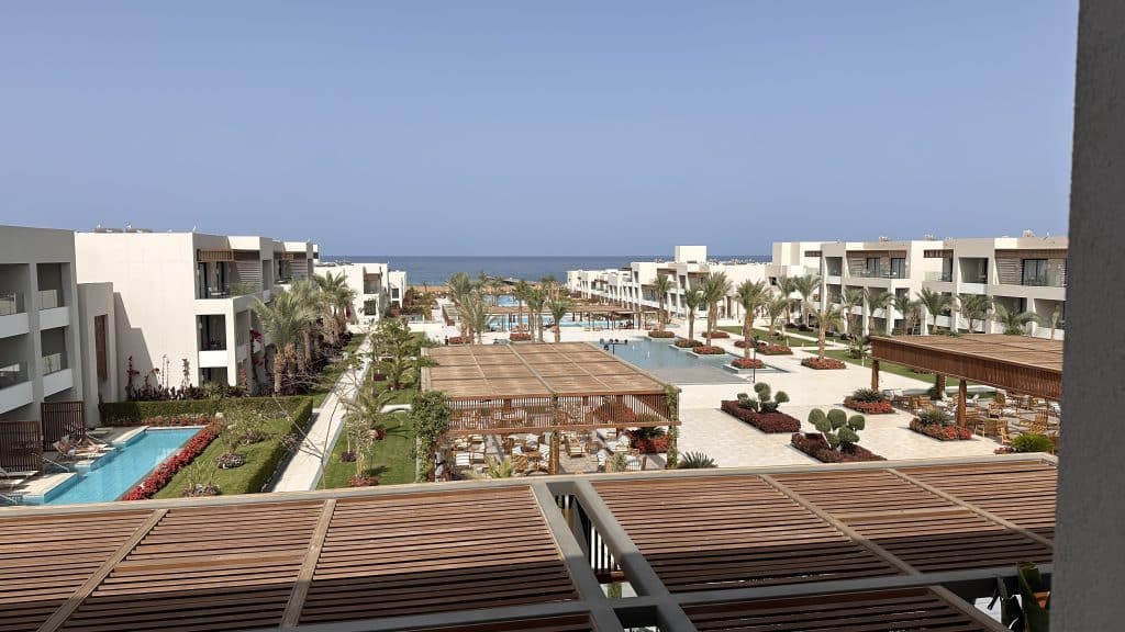 View over the Jaz Elite Amara resort in Marsa Alam with pools, palm trees and low-rise suites leading down to the Red Sea, a relaxing add-on to a 10-Day Egypt Itinerary.