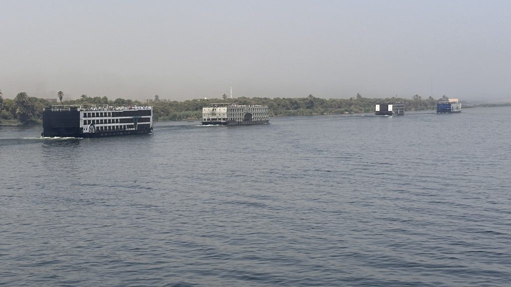 Several Nile cruise ships sailing north from Aswan towards Kom Ombo on Day 5 of a 10-Day Egypt Itinerary.